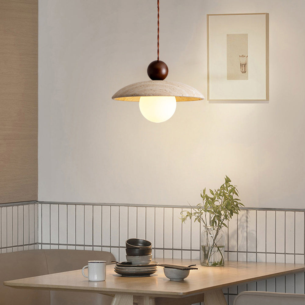 Travertine pendant light above wooden dining table