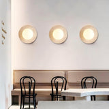 Three travertine wall sconces in a row, cafe interior lighting