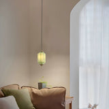 Green ceramic pendant lamp in a cozy living room with arched window