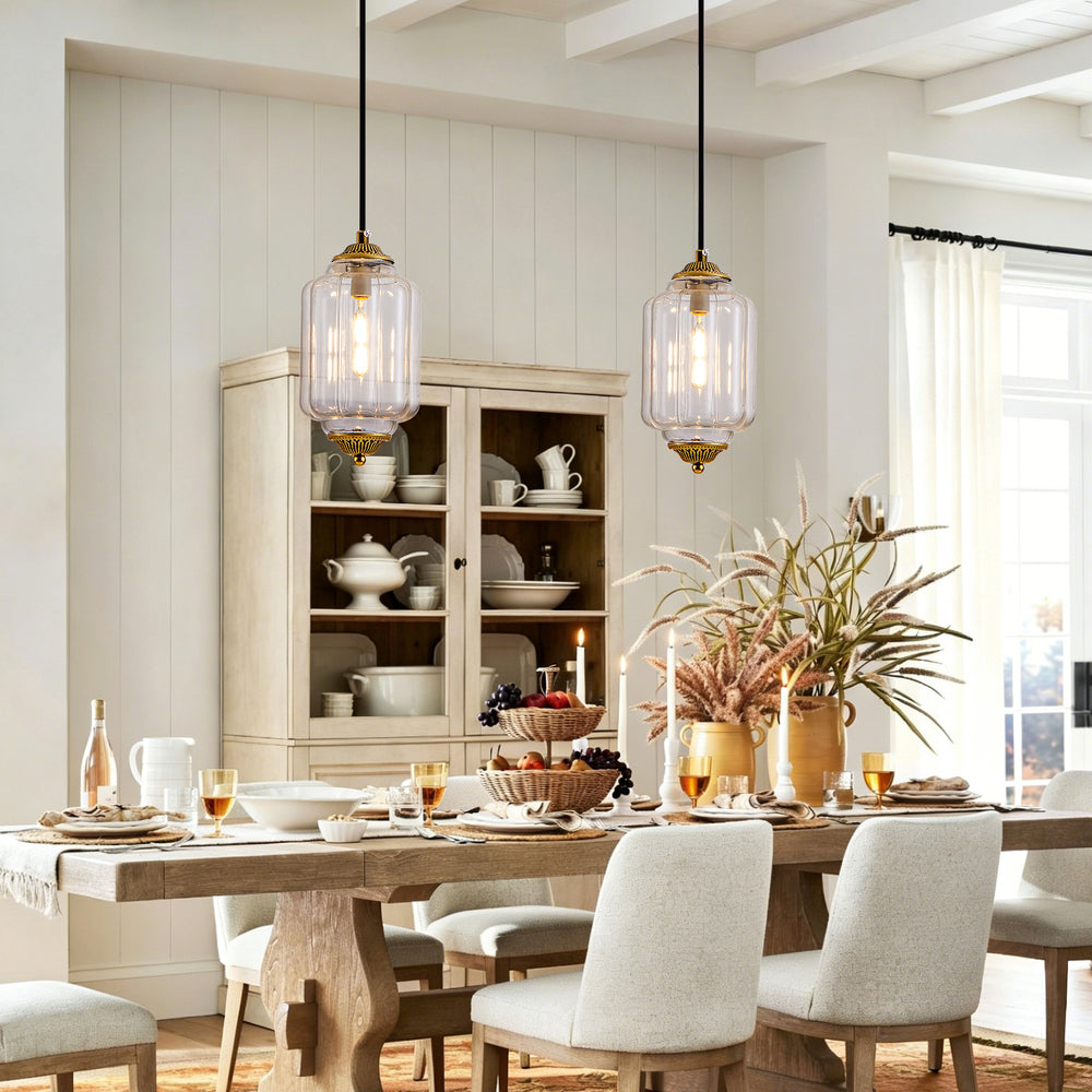 Two vintage clear glass bronze pendant lights over farmhouse wooden dining table
