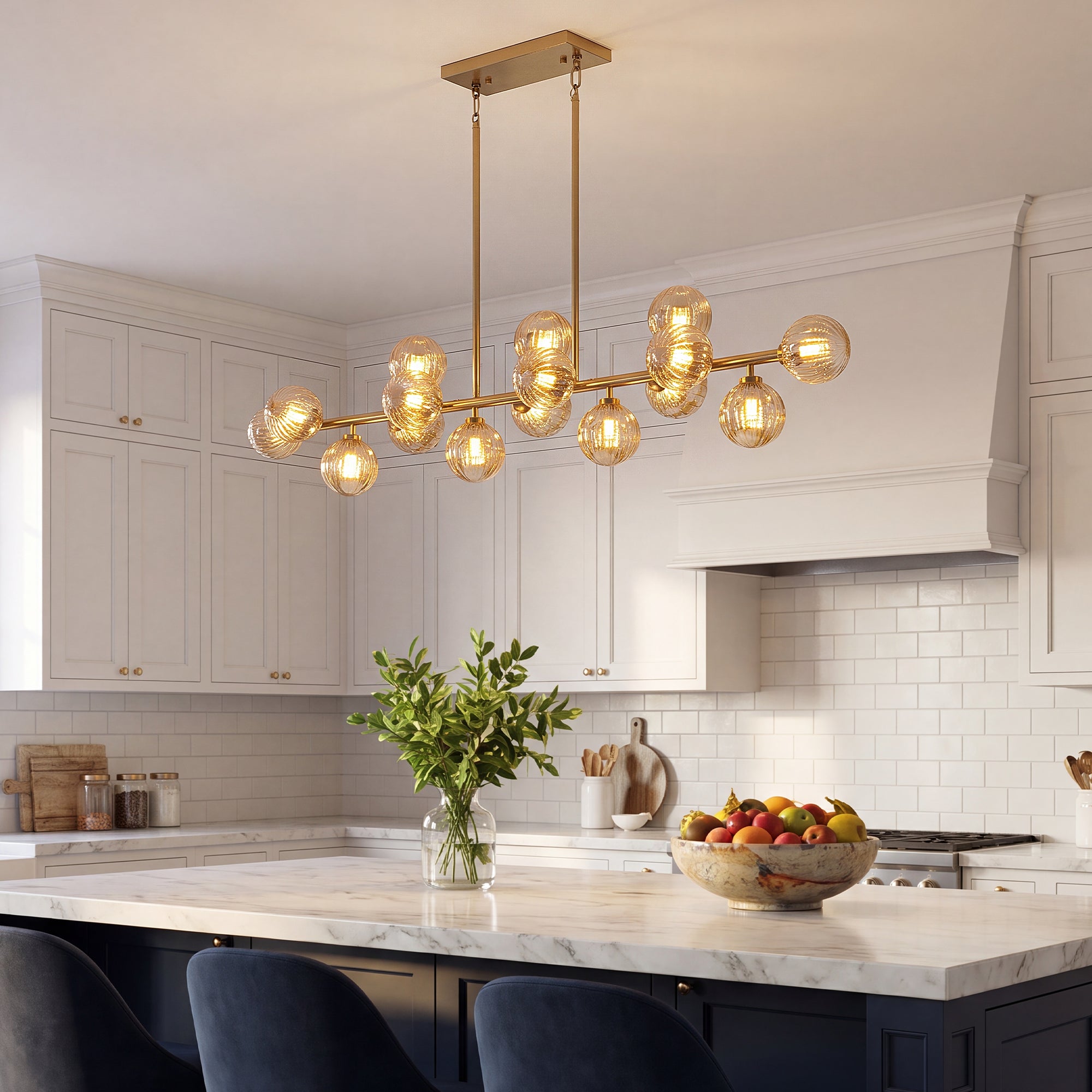  Gold amber glass globe linear chandelier above marble white cabinet kitchen island