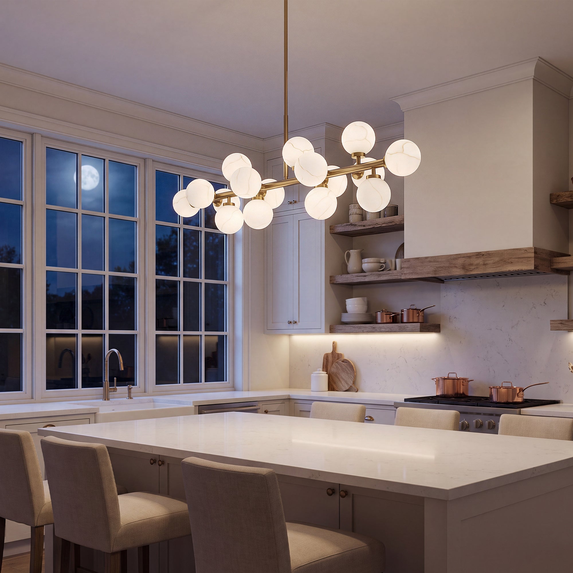 Gold alabaster globe linear chandelier above modern white kitchen island night scene