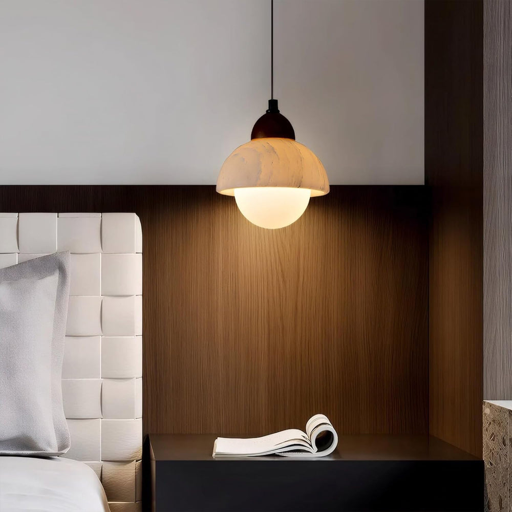 Marble pendant light illuminating a modern bedroom bedside table