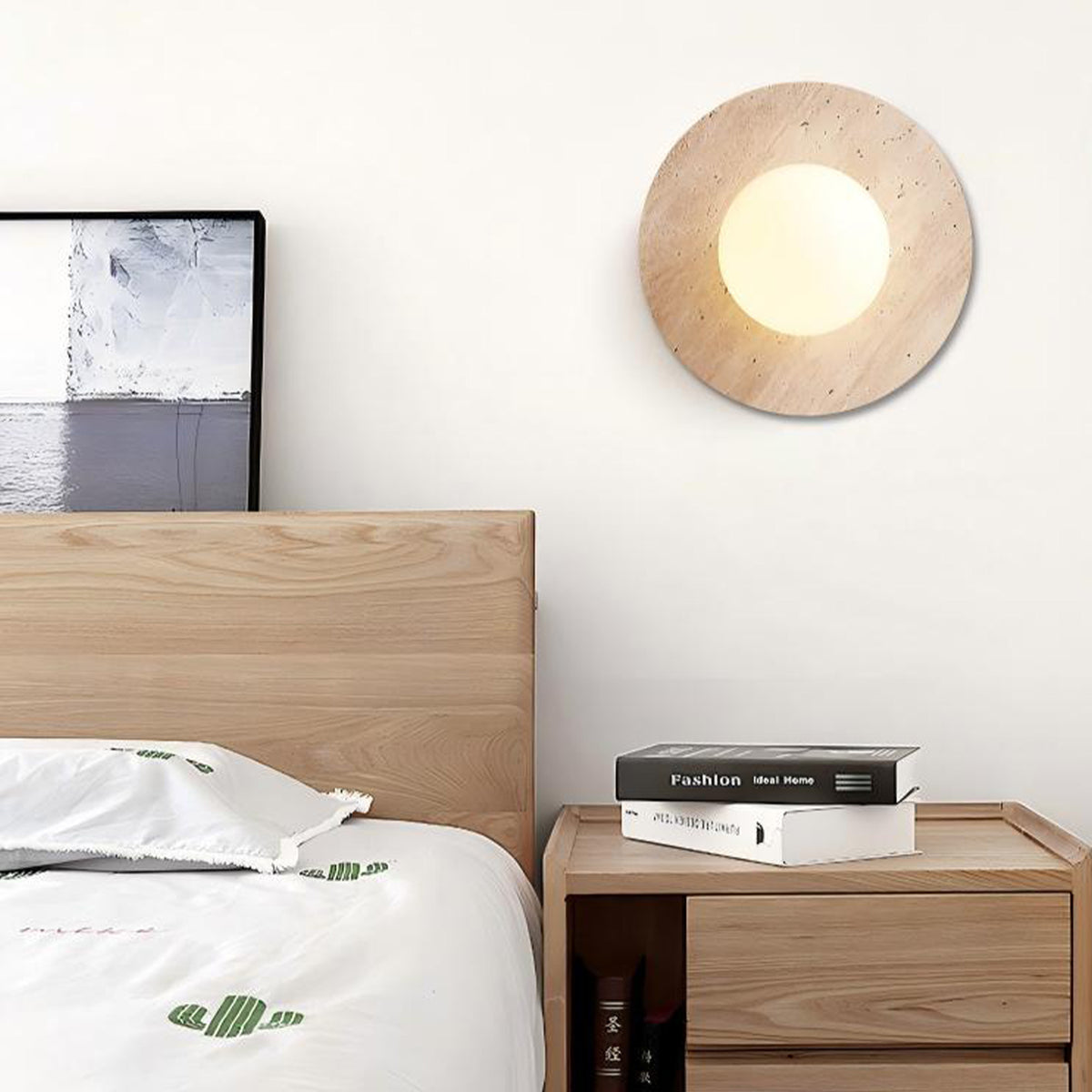 Natural travertine wall sconce beside wooden bed frame, warm glow