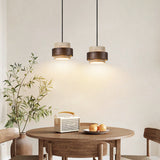 Two Yellow Travertine & Wood Pendant Lights Hanging Above a Wooden Dining Table - Rustic Organic Kitchen Lighting Idea